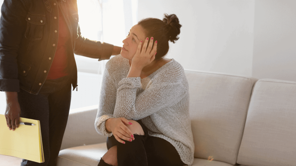 Woman receiving emotional support from a counselor in a therapy session.