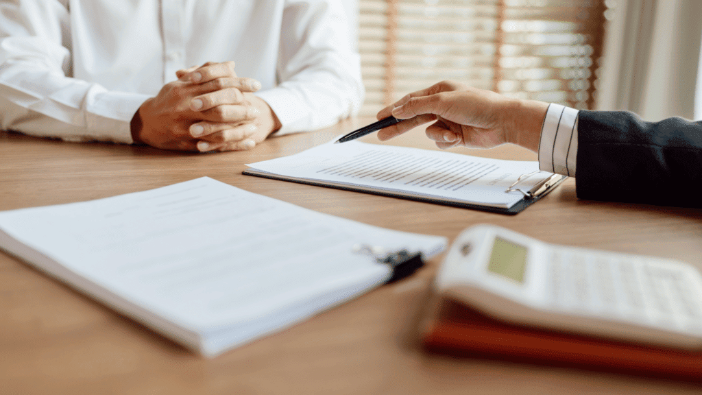 Business meeting with documents and a pen on a wooden table.